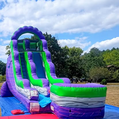 Purple and green inflatable water slide with pool